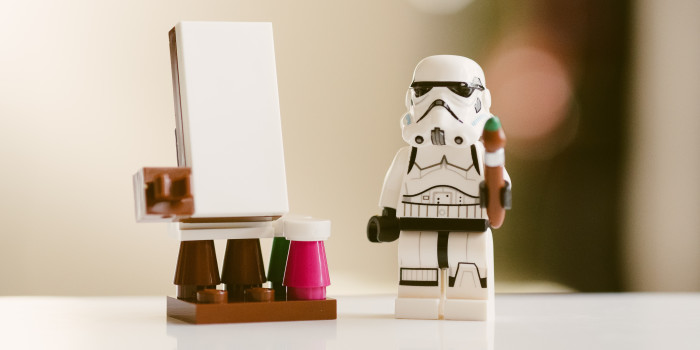 Lego figure standing next to blank canvas